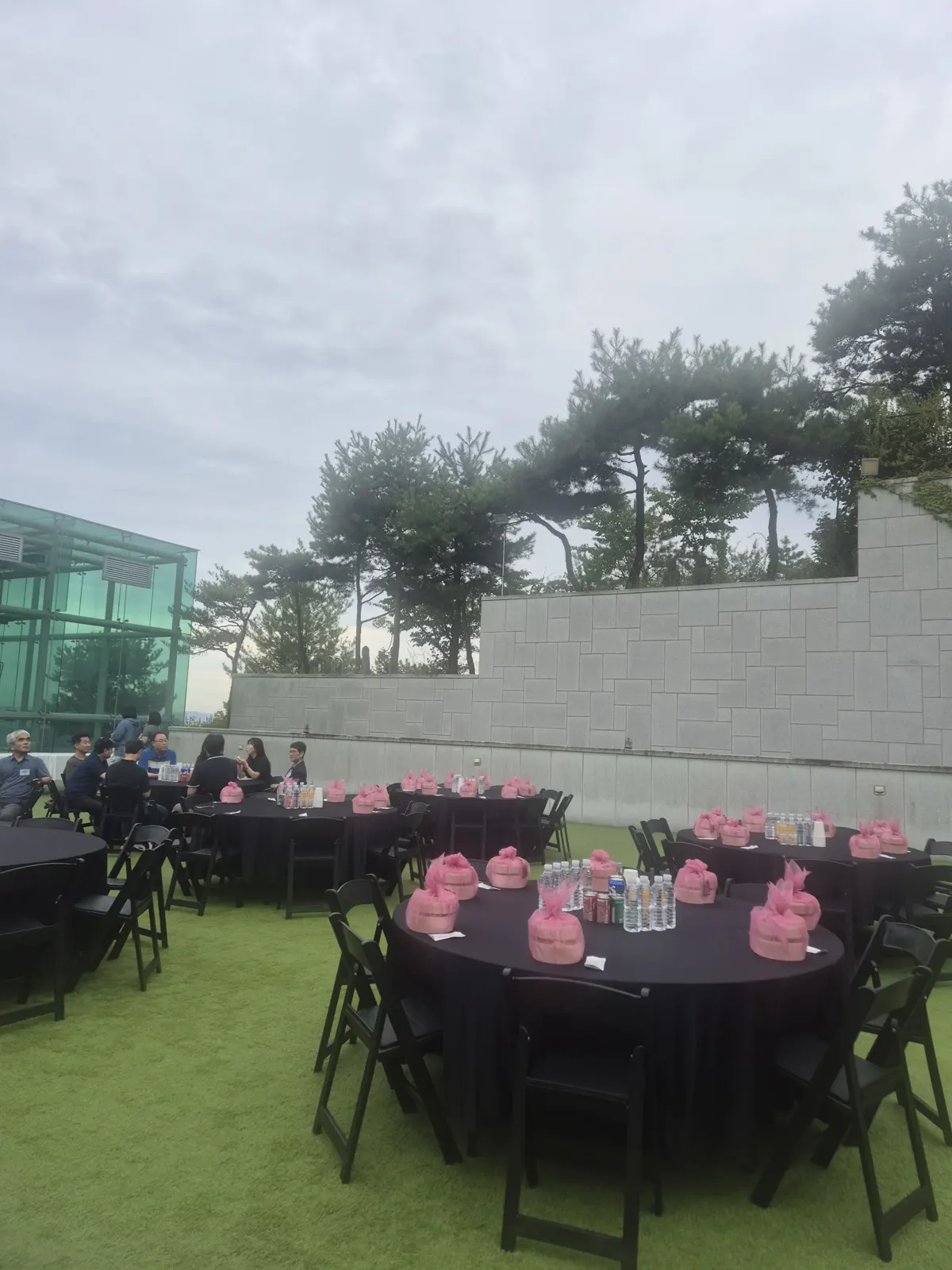 성북동 박물관 야외 잔디 원형 테이블에 참석자가 앉고 보자기 도시락이 놓인 모습