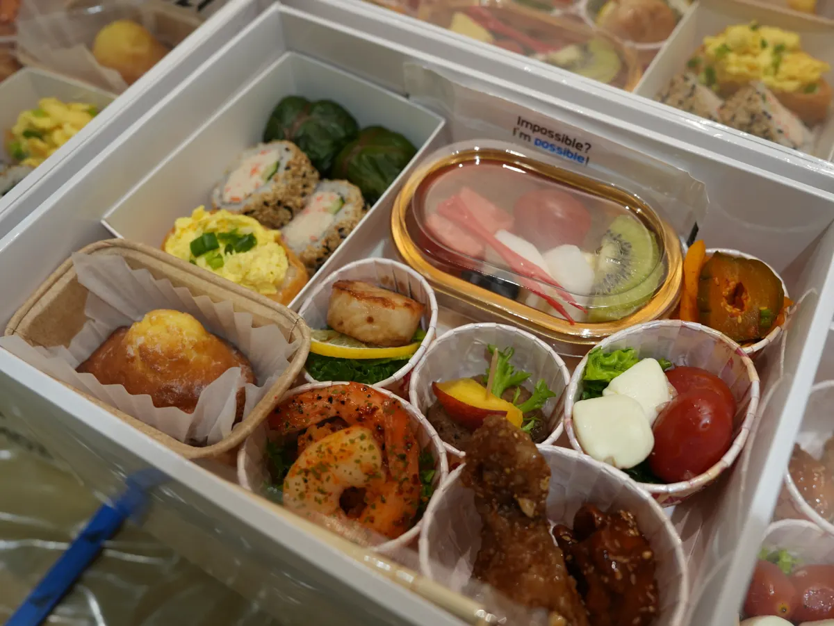 강남 회사 회의 도시락 박스 한 개에 롤과 새우, 과일을 칸별로 담아 완성한 구성