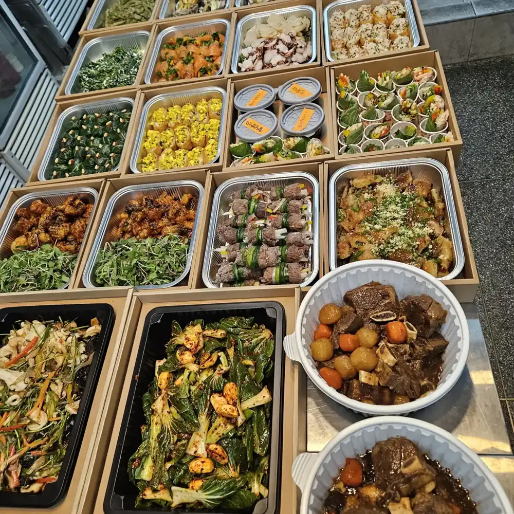 서울 칠순잔치 홈파티 음식배송용 갈비찜을 흰 용기에 담아 다른 요리와 나란히 놓은 모습